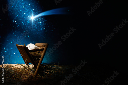 Leinwand Poster Nativity of Jesus, empty manger at night with bright lights.
