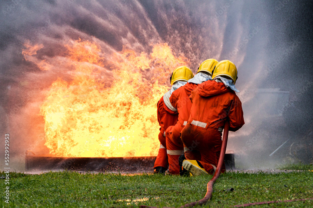 Firefighter Concept. Fireman using water and extinguisher to fighting