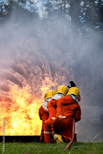 Firefighter Concept. Fireman using water and extinguisher to fighting with fire flame. firefighters fighting a fire with a hose and water during a firefighting training exercise