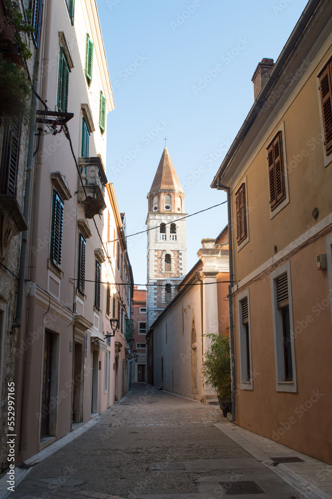 Narrow street by the church of Saint Simeon with bell tower in Zadar, Croatia