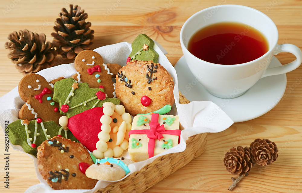 Closeup a Basket of Christmas Cookies and a Cup of Hot Tea on Wooden Table Closeup a Basket of Christmas Cookies and a Cup of Hot Tea on Wooden Table
