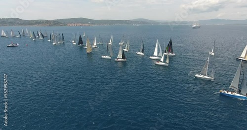 epic aerial view shots of the start of the Rolex Giraglia 2019 regatta, many sailing yachts have started and are making maneuvers dramatic sky photo