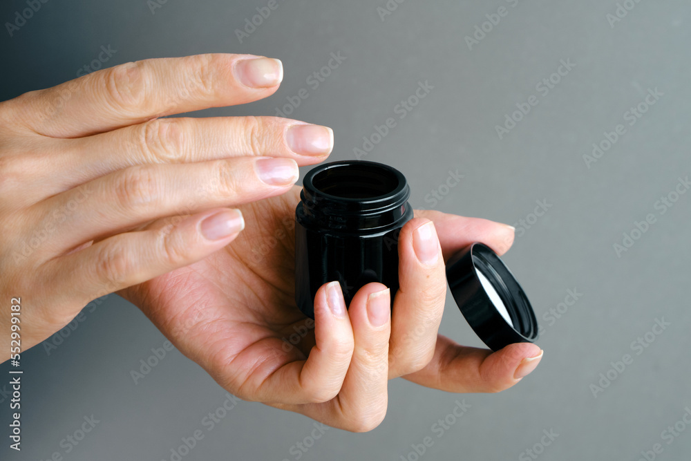 A jar of spa cream in the hands of a girl. Skin care. Medical and dermatological cosmetics for hands. Beauty and health of a woman. Spa treatments for the body. Container with natural cream close-up A jar of spa cream in the hands of a girl. Skin care. Medical and dermatological cosmetics for hands. Beauty and health of a woman. Spa treatments for the body. Container with natural cream close-up