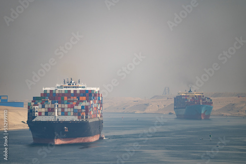 Many cargo ships navigate through Suez Canal. Shipping canal in Egypt. Concept of transportation and logistics 