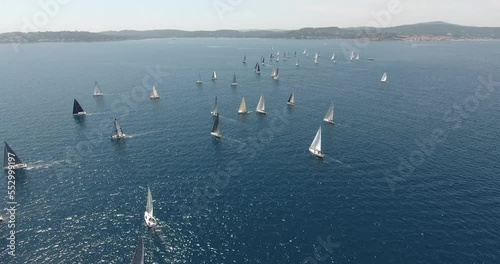 epic aerial view shots of the start of the Rolex Giraglia 2019 regatta, many sailing yachts have started and are making maneuvers dramatic sky