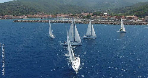 epic shot sailing yachts compete on the background of the coast of an Italian town photo