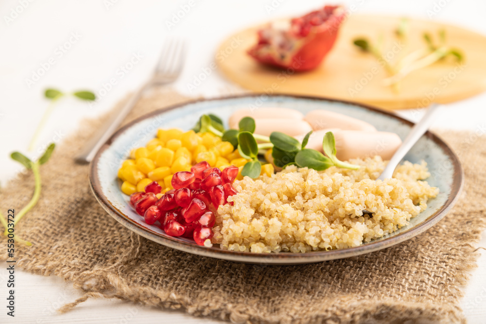 Mixed quinoa porridge, sweet corn and small sausages on white wooden, side view, selective focus. Mixed quinoa porridge, sweet corn and small sausages on white wooden, side view, selective focus.