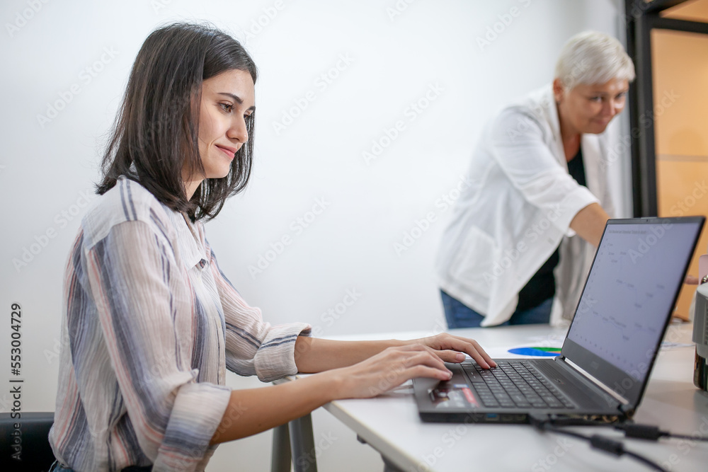 business team female colleagues talking at work share ideas with laptop, Happy colleagues work together, CEO executive in corporate office. business team female colleagues talking at work share ideas with laptop, Happy colleagues work together, CEO executive in corporate office.