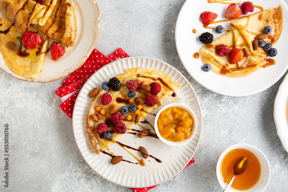 Crepes with berries and jam on plate breakfast food on light surface Pancakes day
