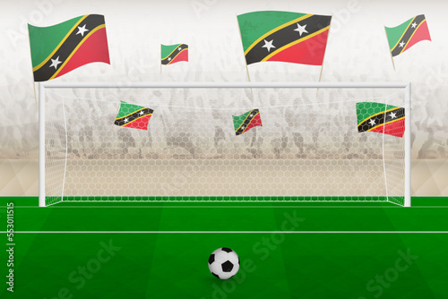 Saint Kitts and Nevis football team fans with flags of Saint Kitts and Nevis cheering on stadium, penalty kick concept in a soccer match.