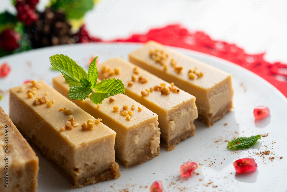 Cheesecake and almond nougat. Typical Christmas dessert served on a table with Christmas decorations. Cheesecake and almond nougat. Typical Christmas dessert served on a table with Christmas decorations.