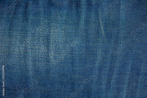 Blue denim background. Texture of classic frayed jeans