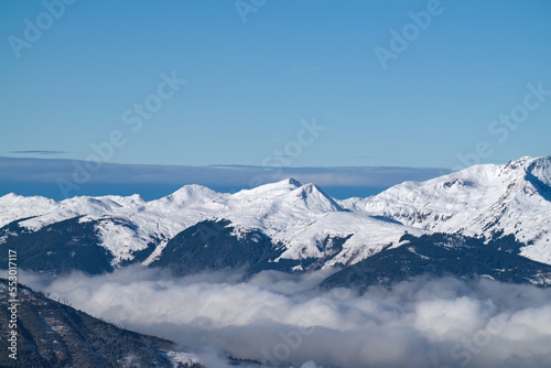 beautiful view to the snow capped alps in austria at a sunny and cold winter day