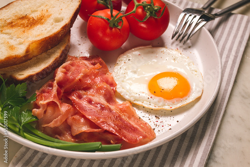 Breakfast  fried egg  bacon and bread  with cherry  on a light background  homemade  no people 