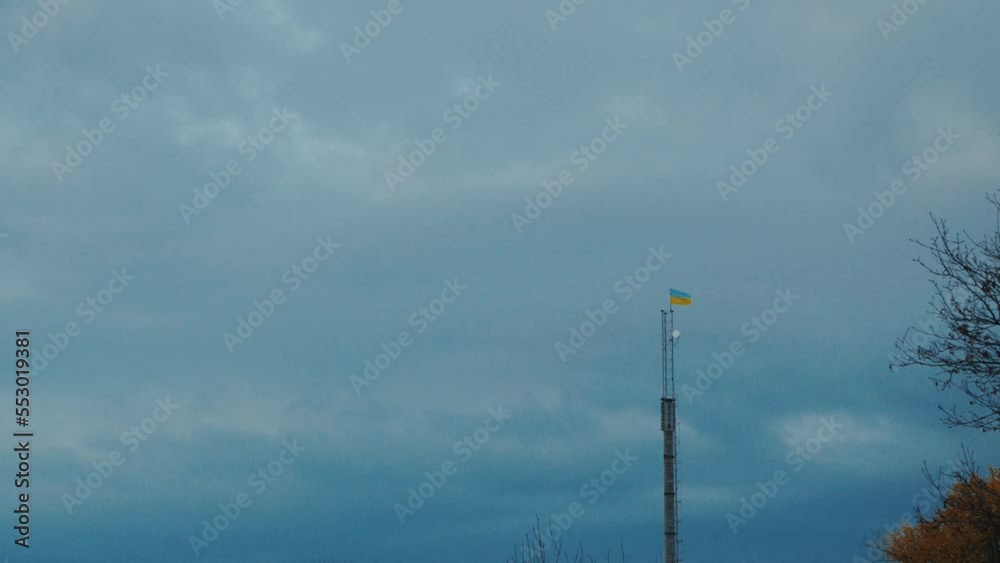 the flag of Ukraine in the autumn park against the background of the blue sky. flag of Ukraine on a high tower. the flag of Ukraine in the autumn park against the background of the blue sky. flag of Ukraine on a high tower.