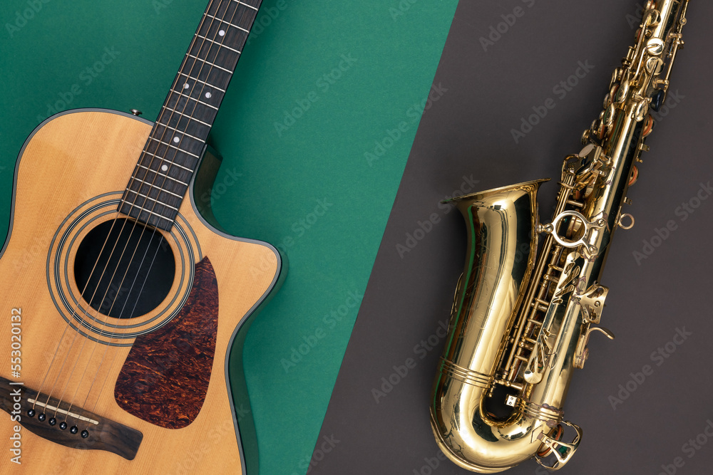 Naklejka premium Guitar and saxophone on paper background, top view.