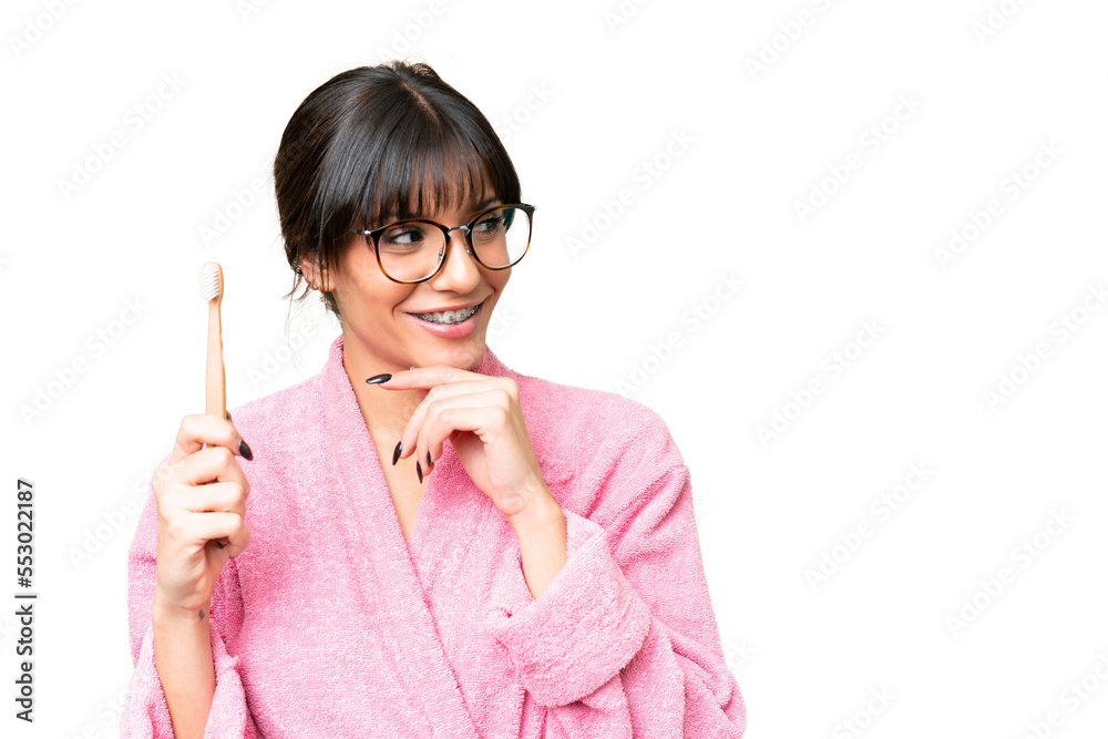 Young caucasian woman holding a toothbrush over isolated chroma key background thinking an idea and looking side Young caucasian woman holding a toothbrush over isolated chroma key background thinking an idea and looking side