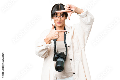 Young photographer caucasian woman over isolated chroma key background focusing face. Framing symbol