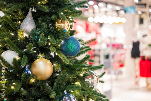 christmas tree in the mall for christmas with garland and decorations on blurred bokeh background