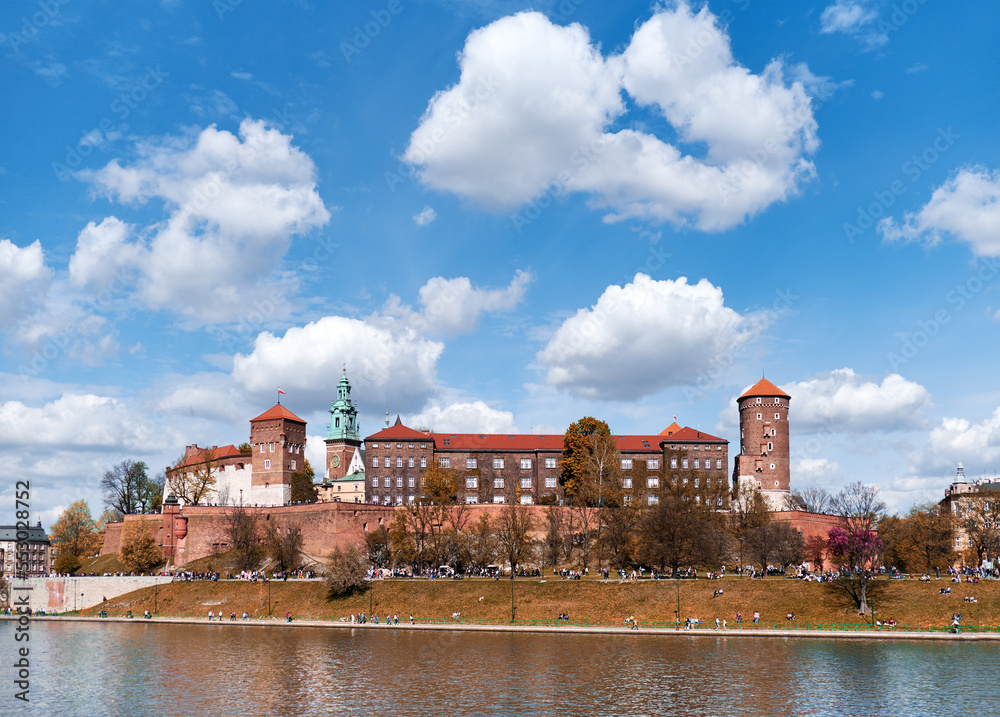 Fototapeta premium Riverside of Krakow City in Poland with Wawel castle view. Shot taken from across river Vistula. Summer day, blue sky with clouds.