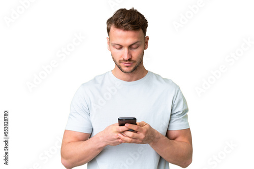 Young handsome caucasian man over isolated chroma key background using mobile phone © luismolinero