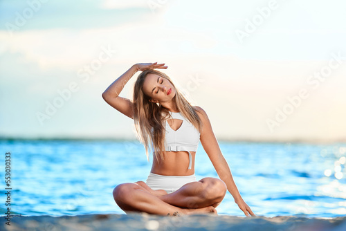Wallpaper Mural athletic young woman practicing yoga exercises on the shore. Torontodigital.ca