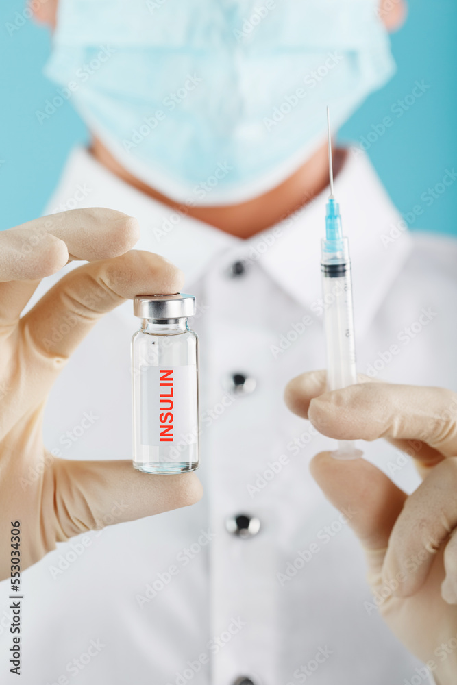 The doctor holds a syringe for injections and an ampoule with insulin for the treatment of Diabetes The doctor holds a syringe for injections and an ampoule with insulin for the treatment of Diabetes
