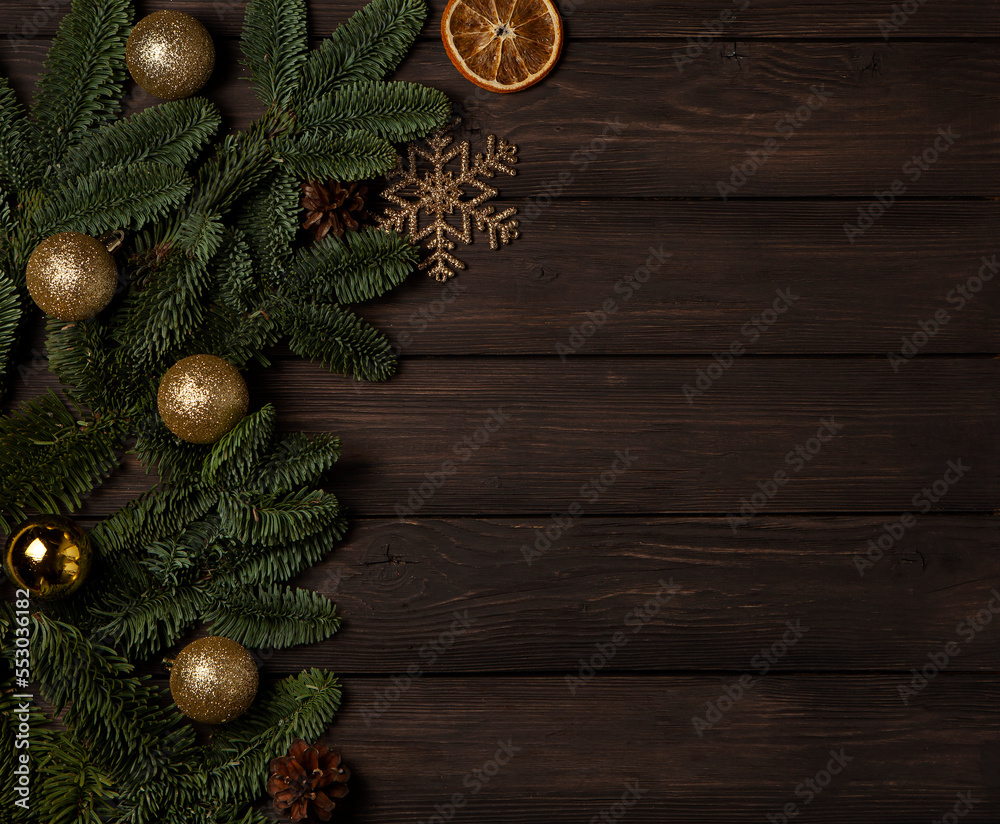 Frame made of Christmas tree branches with gold balls on a dark wooden background.New Year,Christmas concept. Copy space for text, top view Frame made of Christmas tree branches with gold balls on a dark wooden background.New Year,Christmas concept. Copy space for text, top view