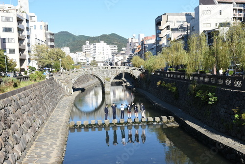 Teenagers (schoolgirls and schoolboys) in school uniforms at the famous Meganebashi Bridge in Nagasaki photo