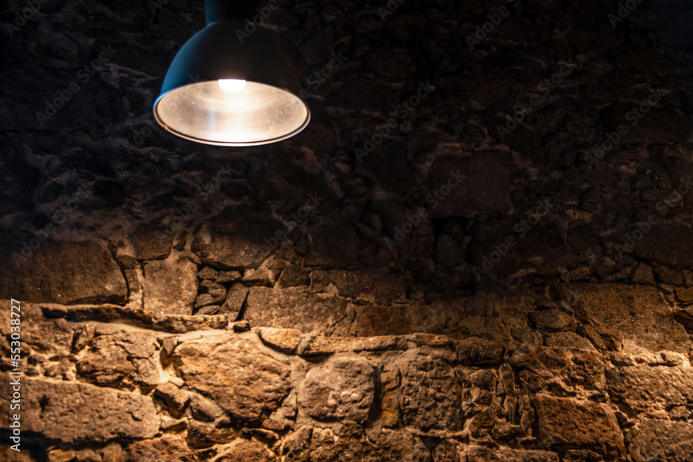 A metal lamp against the old stone wall