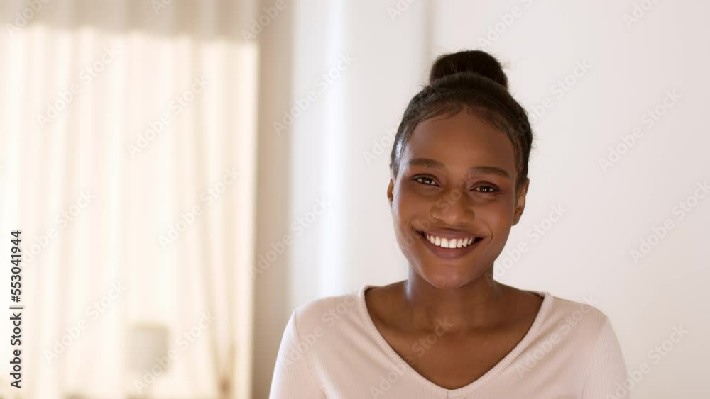 Natural beauty. Close up portrait of young peaceful african american woman smiling to camera at home, empty space Natural beauty. Close up portrait of young peaceful african american woman smiling to camera at home, empty space