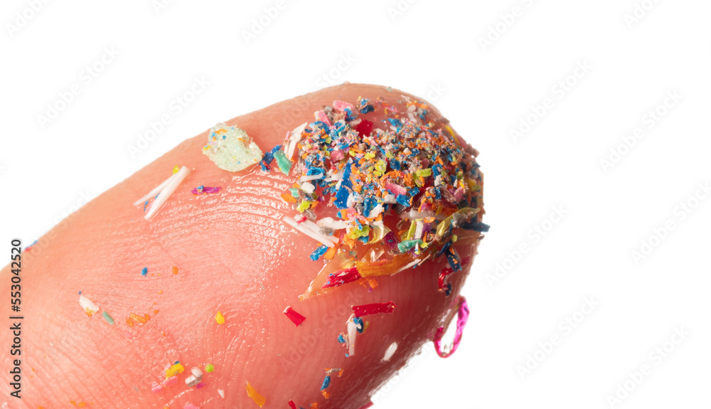 Fototapeta premium Microplastics in water - polluted water - macro photography of finger with microplatics peaces