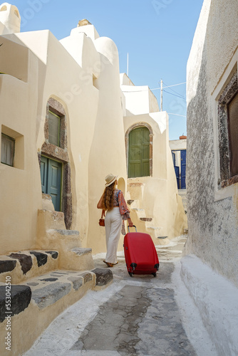 Young woman with a red suitcase travels