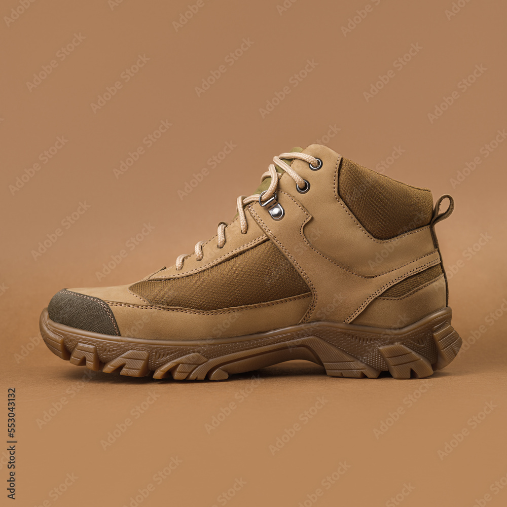 Military sneakers on a beige background. Khaki army shoes