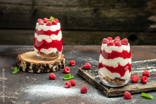 Cranachan raspberry dessert in jar on a dark background. Long banner format