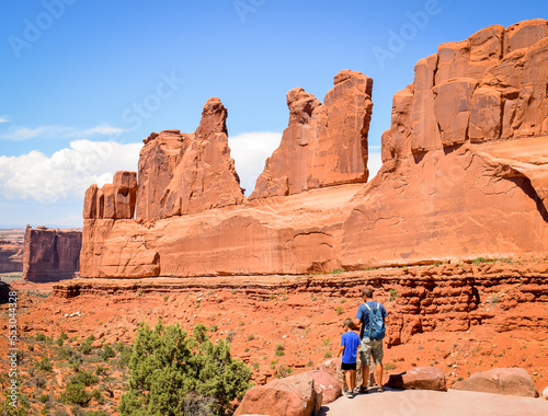 Father and son go hike between the rocks of arches national park photo