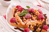 Waffles with raspberries and chocolate cream.