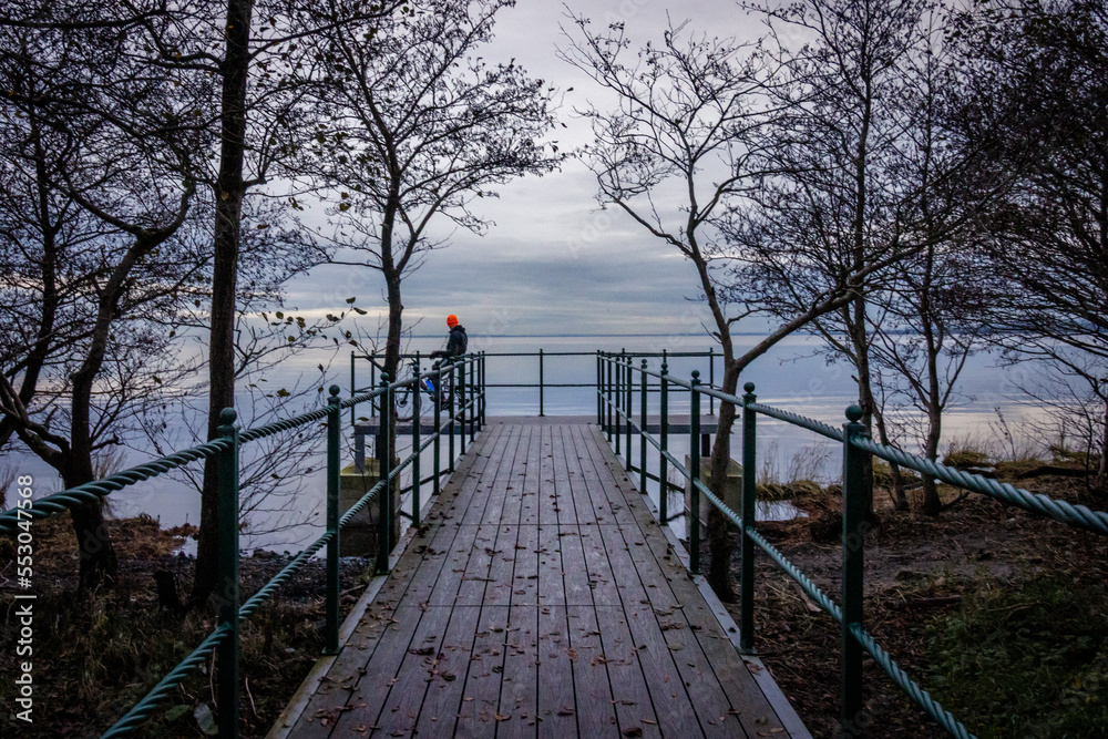 Wooden pier over the lake. Calm and peaceful view at sunset. Lough Neagh, Northern Ireland, UK Wooden pier over the lake. Calm and peaceful view at sunset. Lough Neagh, Northern Ireland, UK