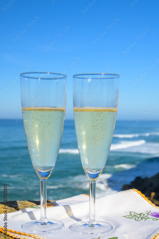 Glasses of champagne sparkling wine and view on blue Atlantic ocean, Lisbon area, Portugal Glasses of champagne sparkling wine and view on blue Atlantic ocean, Lisbon area, Portugal