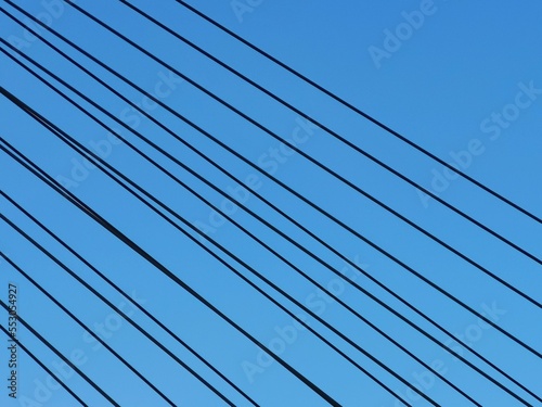 Power transmission lines against deep blue sky with copy space