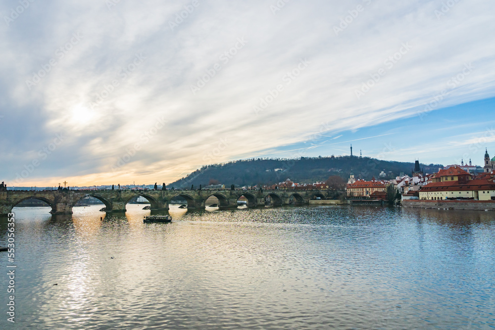 Prague cityscape - winter view of Vltava river, tourist boat, Charles Bridge, old town in Prague, Czech Republic. Taken in the city center of Prague.