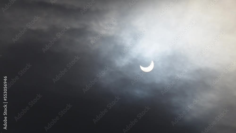 A solar eclipse in cloudy weather through a cloud. partial solar eclipse. A solar eclipse in cloudy weather through a cloud. partial solar eclipse.