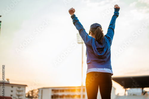 Healthy young woman hand fighting on track race at sport stadium in the city in the morning.Jogging, fitness, running, exercise, lifestyle, healthy concept.