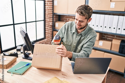 Young man ecommerce business worker scanning package at office