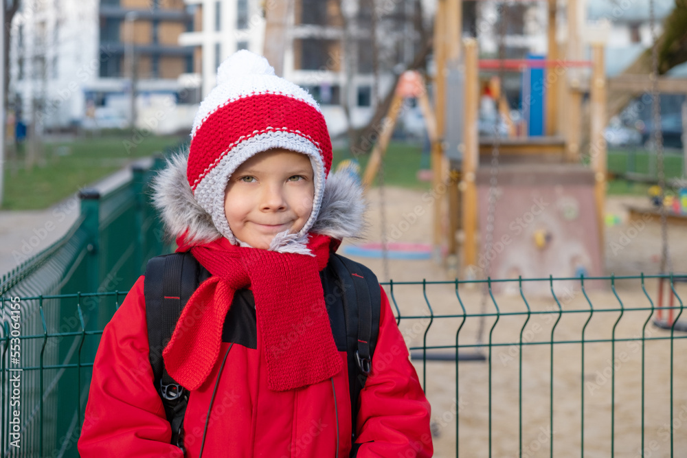 6-year-old boy in bright grass jacket near children's playground in city. 6-year-old boy in bright grass jacket near children's playground in city.