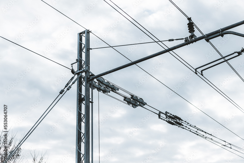 Railroad railway overhead power lines against blue sky. Contact wire.