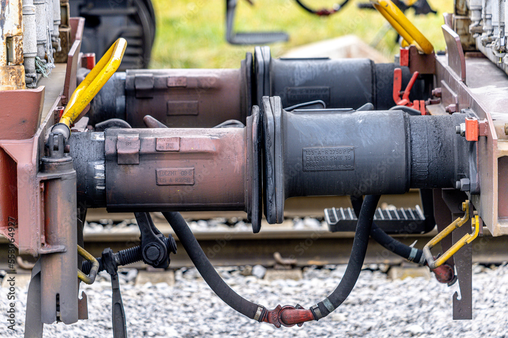 Close up detail of iron connection of two train wagons. Railway car coupler and train buffers. Buffers and chain coupler.