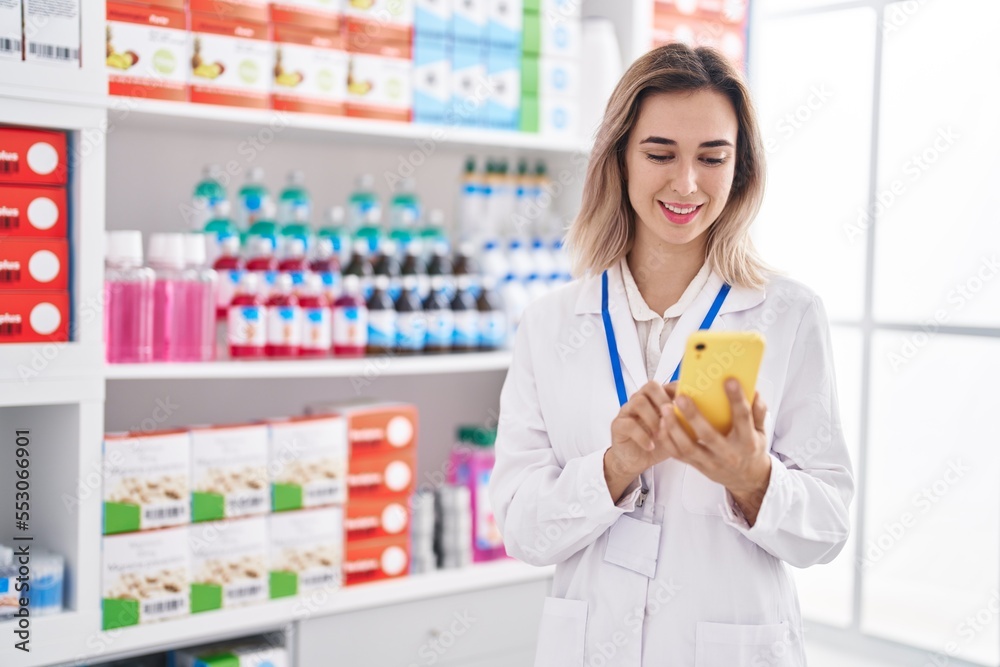 Young woman pharmacist smiling confident using smartphone at pharmacy Young woman pharmacist smiling confident using smartphone at pharmacy