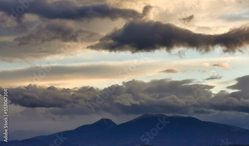 Nuvole nere e cielo azzurro sopra le montagne © GjGj