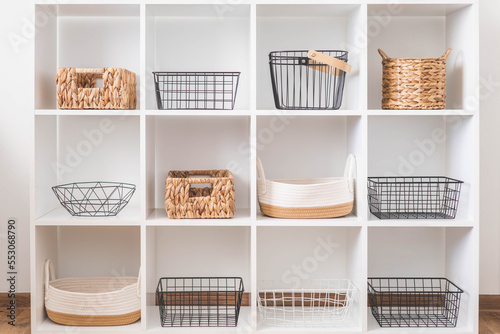 White stylish shelf in scandi style. Storage baskets. Japanese method organizer boxes set. 